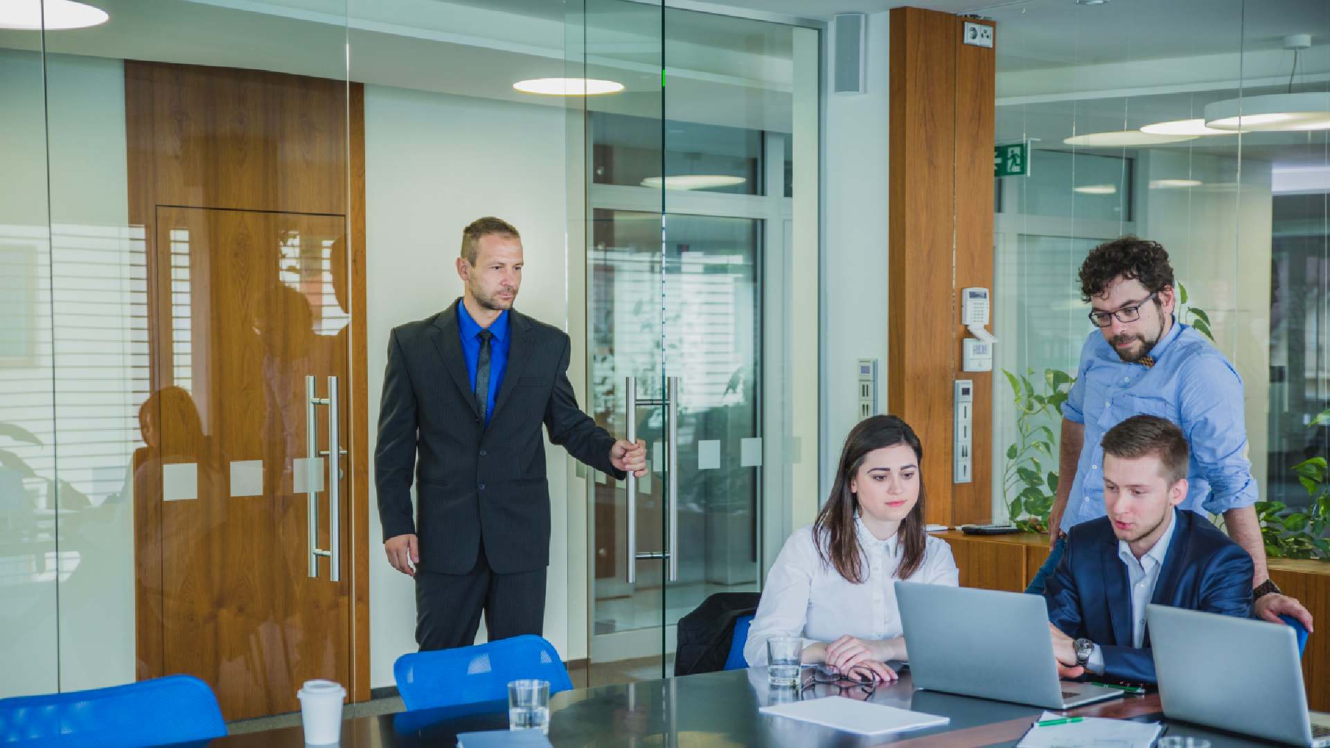 man-entering-room-with-coworkers