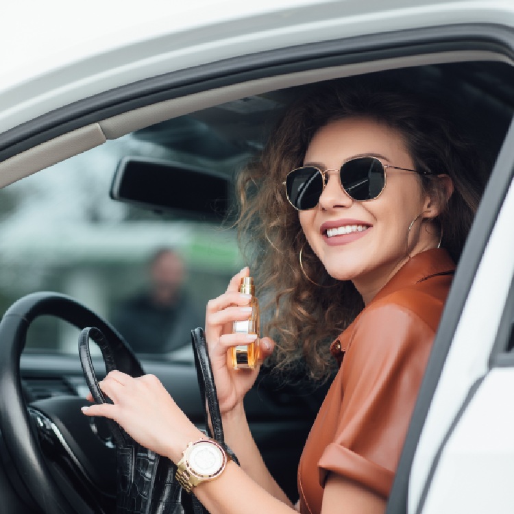portarit-businesswoman-using-her-perfume-car